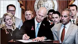  ?? MARK WALLHEISER/AP ?? Gov. Rick Scott said the law he signed showed “government can and has moved fast.”