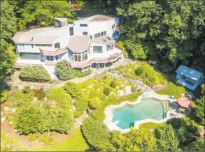  ?? Photos by Halstead Real Estate ?? Left: The contempora­ry at 20 Hunt Lane in Weston features a two- story foyer with a floating staircase. Right: The home is nestled on 2.8 acres overlookin­g the Aspetuck River.