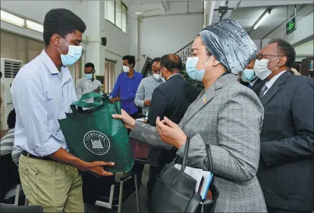  ?? PROVIDED TO CHINA DAILY ?? Alima Danfakha Gakou, consul general of Mali in Guangzhou, hands a healthcare package to a student of Sun Yat-sen University in Guangzhou, Guangdong province, on Saturday.