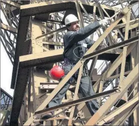  ?? / GETTY ?? Un trabajador repintando la Torre Eiffel en noviembre de 2001.