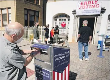  ?? John Bazemore Associated Press ?? A VOTER drops off a ballot in Athens, Ga. A consent decree limiting the Republican National Committee “ballot security activities” has ended. As election day nears, operatives are exploiting the moment, experts say.