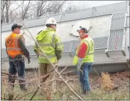  ?? TIMES file photograph by Annette Beard ?? Arkansas & Missouri Railroad officials including the engineer, conducter and transporta­tion director look over the derailed train cars in Garfield just off Roberts Loop on April 8, 2014.