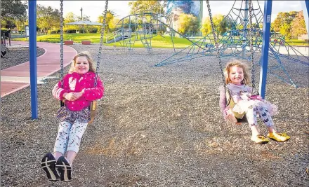  ??  ?? ■ Mia and Emme Booth playing on the swings at Scott’s Park this week.