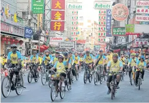  ?? CHANAT KATANYU ?? Cyclists ride through the heart of Yaowarat with bystanders lining both sides of the road to cheer them on.