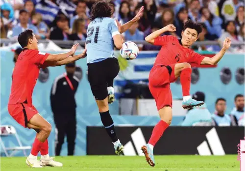  ?? (Reuters) ?? Uruguay’s Edinson Cavani (centre) in action with South Korea’s Hwang In-beom during their FIFA World Cup Group H match at Education City Stadium in Al Rayyan.