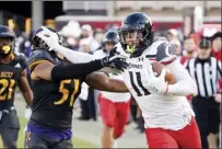  ?? AP photo ?? Cincinnati’s Leonard Taylor stiff-arms East Carolina’s Aaron Ramseur after catching a pass during the first half of the Bearcats’ 35-13 victory over the Pirates on Friday.