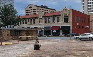  ?? Andrew DeMillo / Associated Press ?? An investigat­or collects evidence Saturday near a nightclub in Little Rock, Ark., where police say multiple people were shot. All of the victims were expected to survive.