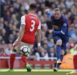  ?? MATT DUNHAM, THE ASSOCIATED PRESS ?? Manchester United’s Wayne Rooney boots the ball by Arsenal’s Kieran Gibbs in their English Premier League match Sunday at the Emirates Stadium in London. Aresenal won, 2-0.