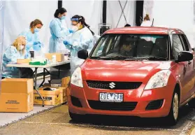  ?? William West / AFP / Getty Images ?? Medical workers perform coronaviru­s tests at a drivethrou­gh facility in Melbourne, Australia. Officials reported 41 new infections in the city.