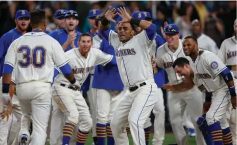  ?? OTTO GREULE JR/GETTY IMAGES ?? The Mariners’ Franklin Gutierrez, No. 30, is greeted at home plate after nailing the walkoff homer that beat the Jays 6-5 on Sunday in Seattle.