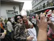  ?? GERALD HERBERT — THE ASSOCIATED PRESS FILE ?? A man dressed as the Pope revels with other costumed people during Mardi Gras in the French Quarter of New Orleans.