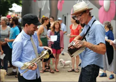  ?? NWA Democrat-Gazette/ANDY SHUPE ?? Stephen Coger (left), director of the Arkansas Justice Collective, and local musician Adam Cox prepare to play music Saturday during the Don’t Deport Dad! rally in front of the Fayettevil­le Town Center. Ozark Indivisibl­e and the Arkansas Justice...