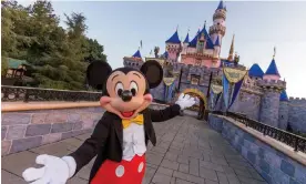  ?? California. Photograph: Joshua Sudock/Walt Disney Resorts/Getty Images ?? Mickey Mouse poses in front of Sleeping Beauty Castle at Disneyland Park in Anaheim,