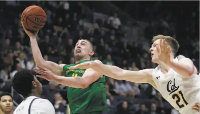  ?? Ben Margot / Associated Press ?? Oregon’s Payton Pritchard goes past Cal's Lars Thiemann (21). Pritchard was held to two points in the first half and scored 19 in the second.