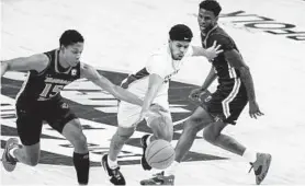  ?? MIKE CAUDILL/AP ?? Norfolk State’s Devante Carter, center, drives past Morgan State’s Tahj-Malik Campbell, left, and Malik Miller during the first half of Saturday’s Mid-Eastern Athletic Conference tournament championsh­ip game in Norfolk, Va.