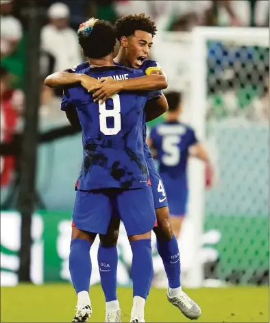  ?? Ashley Landis / Associated Press ?? United States’ Weston McKennie (8) and Tyler Adams celebrate after teammate Christian Pulisic scored a goal during the World Cup group B soccer match against Iran at the Al Thumama Stadium in Doha, Qatar on Tuesday.