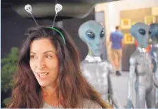  ??  ?? Dana Lenko sports alien antennae during a visit to Roswell’s Internatio­nal UFO Museum and Research Center. Lenko, a fashion designer who was born in Melbourne, Australia, and lives now in Austin, Texas, said she is fascinated by the vastness of space...