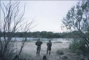  ?? GREGORY BULL — THE ASSOCIATED PRESS ?? Members of the Texas Military Department stand guard along the U.S.-Mexico border Tuesday in Roma, Texas.