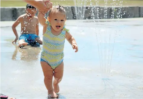 ?? MICHELLE ALLENBERG/WELLAND TRIBUNE ?? With the help of her mom, 11-month-old Rylee McPherson enjoys running through water at the splash pad at Memorial Park in Welland on Tuesday.