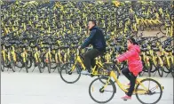  ?? YANG DONG / FOR CHINA DAILY ?? Two customers use Ofo bicycles in Xiangyang, Hubei province.