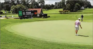  ??  ?? Justin Thomas and his instructor are the only ones around to react to his putt on the 18th green Wednesday during his practice round for the Tour Championsh­ip at East Lake Golf Club.