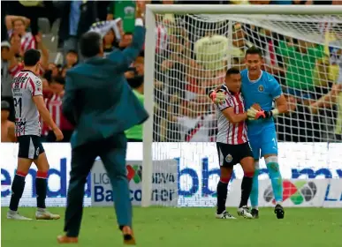  ??  ?? HÉROE. El joven arquero es felicitado después de que el árbitro dio el silbatazo final en el Clásico Nacional.