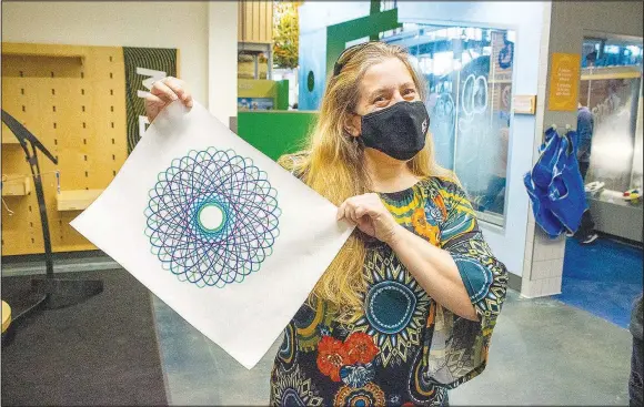  ?? (Courtesy photo) ?? An Amazeum guest displays her work created by using bicycle chain rings and markers.