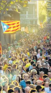  ?? AGENCIES ?? ■ (Above) A wave of pro-independen­ce protesters on the Passeig de Gracia avenue in Barcelona, Spain; (Left): People look at burning tyres during a protest in Dora, Lebanon.