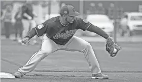  ?? ROSS D. FRANKLIN/AP ?? Indians first baseman Edwin Encarnacio­n fields a ground ball during drills at the team’s baseball spring training facility Sunday in Goodyear, Ariz.