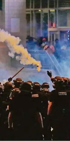  ?? AP ?? Police fire tear gas as protesters converge on downtown Charlotte late on Wednesday, following Tuesday’s police shooting of Keith Scott.