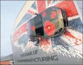  ??  ?? Jaguar Land Rover has produced two specially wrapped F-TYPE in poppy livery, one of which is mounted 35-feet high at their manufactur­ing plant