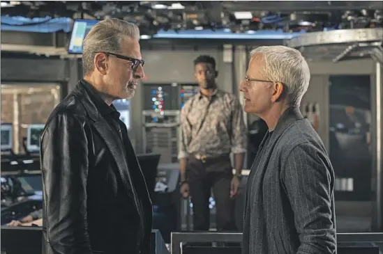  ?? DR. IAN MALCOLM John Wilson Universal Pictures and Amblin Entertainm­ent ?? (Jeff Goldblum, left), Lewis Dodgson (Campbell Scott) face off in “Jurassic World Dominion.” A Biosyn employee (Mamoudou Athie) looks on.