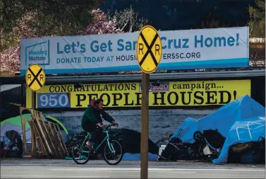  ?? PHOTOS BY KARL MONDON — STAFF PHOTOGRAPH­ER ?? A tent encampment alongside Highway 1 in Santa Cruz sits below a Housing Matters sign boasting of success in getting people off the streets. Caltrans plans to clear the camp later this month in preparatio­n for a highway widening project.