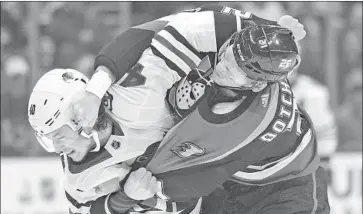  ?? Kyusung Gong Associated Press ?? THE DUCKS’ Jake Dotchin, right, and the Blackhawks’ John Hayden get into a first-period scuffle.