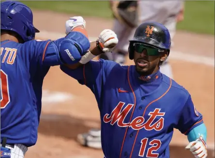  ?? THE ASSOCIATED PRESS ?? New York Mets’ Francisco Lindor (12) is congratula­ted by Michael Conforto after scoring on a solo home run during the fifth inning of a spring training baseball game Miami Marlins, Tuesday, March 23, 2021, in Port St. Lucie, Fla.