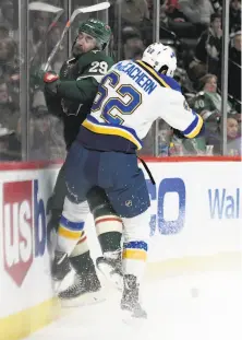  ?? Hannah Foslien / Associated Press ?? St. Louis left wing Mackenzie MacEachern checks Minnesota defenseman Greg Pateryn into the boards in the first period.