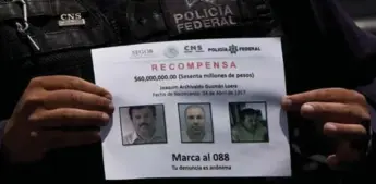  ?? MARCO UGARTE/THE ASSOCIATED PRESS FILE PHOTO ?? A Mexican police officer holds a reward notice for informatio­n leading to the capture of drug lord Joaquin Guzman.