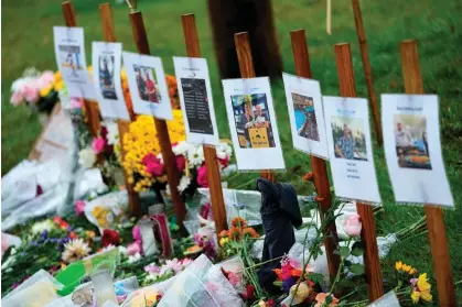  ?? Matt York/AP ?? Memorials for those who died sit along the roadside by Schemengee­s Bar & Grille in Lewiston, Maine, on 30 October 2023. Photograph: