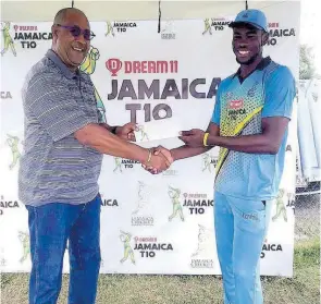  ?? LENNOX ALDRED ?? Surrey Risers fast bowler Khari Campbell (roght) accepts his Man Of The Match award from Jamaica Cricket Associatio­n Director Michael Atterbury for his four wickets against the Surrey Risers in the Dream11 Jamaica T10 competitio­n at Sabina Park in Kingston yesterday.