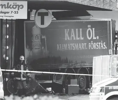  ?? JONATHAN NACKSTRAND / AFP / GETTY IMAGES ?? Emergency services work at the scene where a stolen beer truck crashed into the Ahlens department store in Stockholm on Friday. A Swedish police spokesman said officials “have a working hypothesis this is an act of terror.”