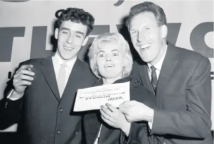  ??  ?? British comedian Bruce Forsyth (right) presents a cheque for £152,319 to Yorkshire miner Keith Howard Nicholson and his wife Vivian, winners of the Littlewood­s Football Pools, September 27, 1961