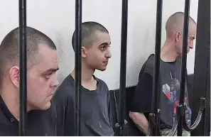  ?? ?? British citizens Aiden Aslin (left) and Shaun Pinner (right), and Moroccan Saaudun Brahim, center, sit behind bars in a courtroom in Donetsk, in territory under the Government of the Donetsk People’s Republic control, eastern Ukraine.