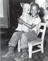  ?? LUIGI MENDICINO/CHICAGO TRIBUNE ?? Leonard Piggee, 5, beams with his new doggie given to him by a Good Fellow at Altgeld Gardens on Dec. 19, 1957.