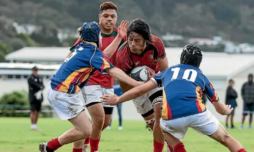  ?? PHOTO: JOE SERCI ?? Bishop Viard College’s Philip Filipo is tackled by Tawa College defenders recently. Viard won 17-13 to qualify for premier 1.