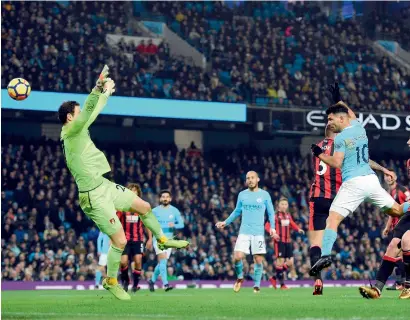  ?? AFP ?? Sergio Aguero heads the ball to score a goal against Bournemout­h during the Premier Leage match at the Etihad Stadium. —