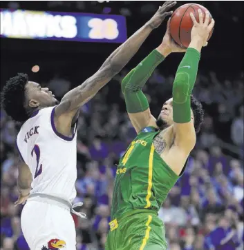  ?? ORLIN WAGNER/THE ASSOCIATED PRESS ?? Oregon forward Dillon Brooks, right, looks to get off a shot past the outstretch­ed arm of Kansas guard Lagerald Vick during the NCAA Tournament Midwest Regional final Saturday in Kansas City, Mo. The third-seeded Ducks beat the No. 1-seeded Jayhawks...