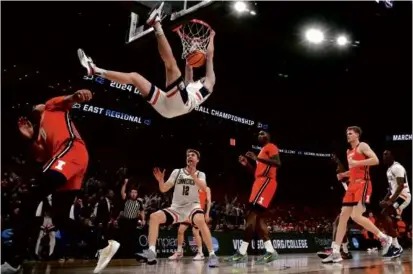  ?? BARRY CHIN/GLOBE STAFF ?? Alex Karaban’s thunderous slam dunk was a signature moment in UConn’s epic 30-0 run.