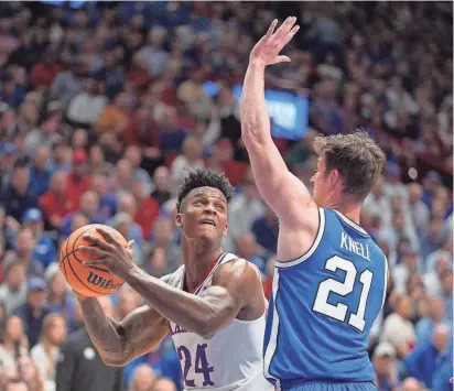  ?? CHARLIE RIEDEL/AP ?? Kansas forward K.J. Adams Jr. looks to shoot over BYU guard Trevin Knell during the first half of a game Tuesday in Lawrence.