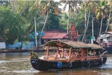  ?? ?? A traditiona­l boat takes a group of Western tourists on a cruise on the backwaters of Alappuzha in Kerala.