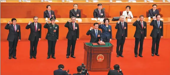  ?? KUANG LINHUA / CHINA DAILY ?? Vice-premiers, State councibm and the secretary-general of the State Council take the oath of allegiance to the Constituti­on during the seventh plenary meeting of the first session of the 13th National People's Congress at the Great Hall of the People...